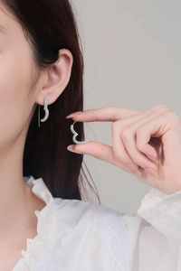 Close-up of pavé heart earrings with cubic zirconia stones worn on ear lobe