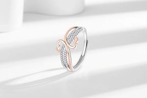 Detail of interlocking silver and rose gold heart ring with sparkling paved zircon stones