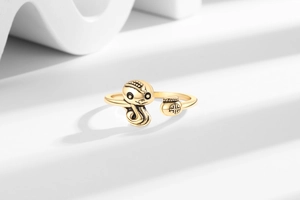Detailed close-up of golden zodiac snake ring with lucky bag on a minimalist stand