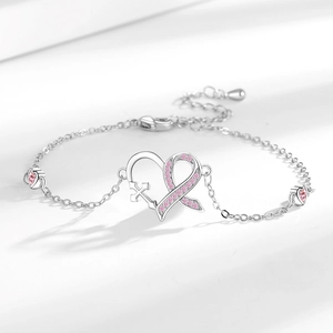 Silver heart bracelet with pink ribbon cross pendant and zircons on white background