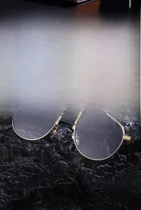 Close-up of golden oval frames and sleek black temples resting on a dark stone texture