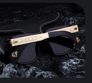 Detail of square polarized sunglasses with golden baroque carved temples and green gemstones