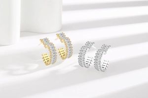 Detail of gold and silver hoop earrings with baguette-cut stones and shadow effect