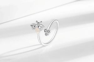 Macro shot of silver firefly and honeycomb ring detail with moonstone and cubic zirconia