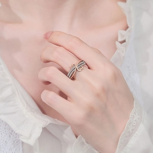 Two-tone heart ring with cubic zirconia infinity design worn by a model in soft lighting