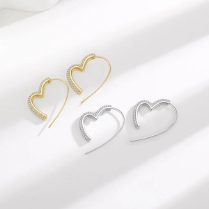 Micro-paved heart earrings in gold and silver finish with sparkling cubic zirconia accents