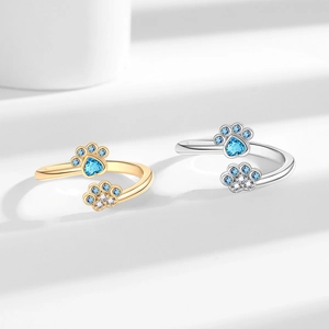 Adjustable paw print rings in gold and silver with heart-shaped blue stones and zircon stones