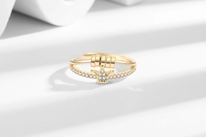 Detail of adjustable gold ring with crown motif, tiny white crystals and spinning beads