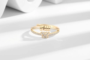Detail of golden butterfly fidget ring with movable beads on white stone base