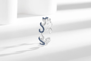 Detailed view of silver wave ring with blue zircon inlay and hollow design