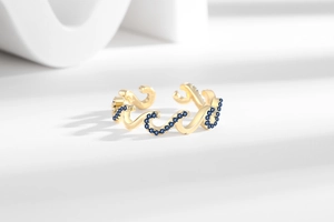 Detailed shot of golden wave ring set with shimmering blue cubic zirconia stones