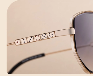 Detail of gold metal temples featuring a unique six-dice design and wavy textured frames