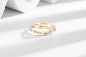 Macro shot of rotatable gold beads and cross motif on a multi-layer anxiety relief ring