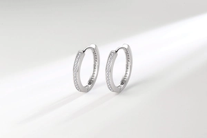Macro detail of silver hoop earrings featuring double rows of micro-pave cubic zirconia