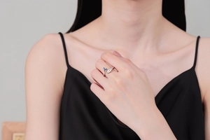 Detail of adjustable silver fishtail ring with blue enamel whale tail design