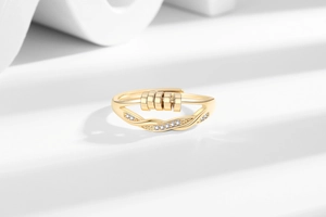 Detail of gold rotating bead ring with white cubic zirconia set on interlaced bands
