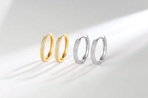 Detail of gold and silver hoop earrings with single row pavé setting cubic zirconia