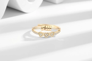 Close-up of golden fidget ring with micro-pave hearts and rotatable beads