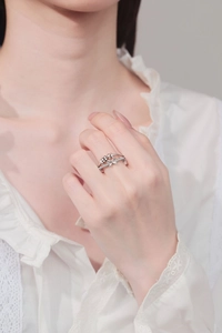 Detail of silver spinner ring with bow knot and movable square beads with crystals