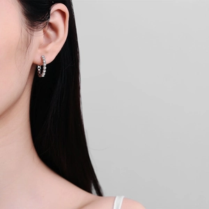 Élégantes créoles bulles en argent avec zircons étincelants portées par un mannequin