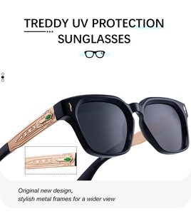 Detail of square black sunglasses with gold temples, embossed patterns, and green accents