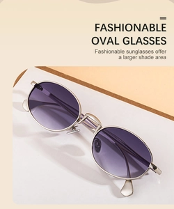 Detail of oval sunglasses with silver metal frames and purple gradient resin lenses