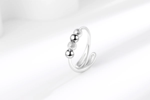 Macro shot of silver adjustable anxiety ring with polished and matte moving beads