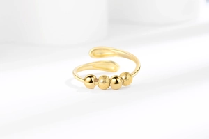 Detailed shot of golden adjustable anxiety ring with polished and frosted beads