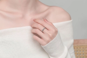 Detail of silver spinner ring with moving beads worn by model on finger for anxiety relief