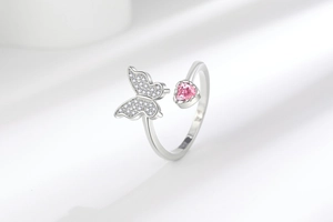 Détail macro d'une bague papillon ajustable avec zircon cœur rose et finition argent