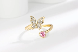 Gros plan détaillé d'une bague papillon avec pierre coeur rose et zircone brillante