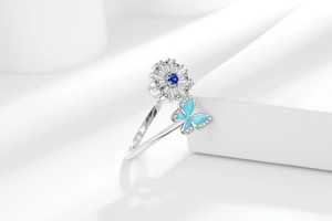 Macro detail of sunflower spinner ring with blue butterfly and crystal accents