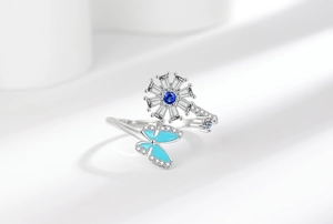 Macro detail of rotating sunflower ring with blue crystal and enamel butterfly accent