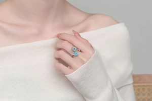 Close-up of adjustable butterfly and daisy fidget ring with turquoise blue enamel details