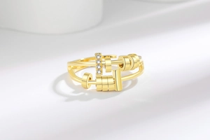 Vue détaillée d'une bague anti-stress dorée avec rails coulissants et quatre zircons