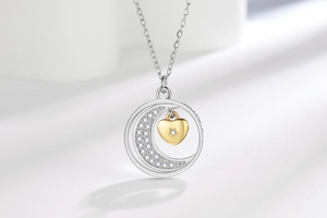Macro shot of silver crescent moon and gold heart pendant with sparkling cubic zirconia