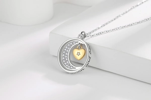 Detail of moon and back engraving on moon and heart pendant necklace with rhinestones