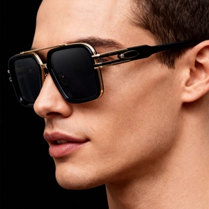 Close-up of golden and black double-bridge metal frame and hollow temple detail on sunglasses