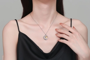 Detail shot of moon and heart pendant necklace with rhinestones on model neck