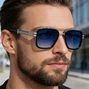 Détail de lunettes aviateur carrées avec double pont et logo bouclier argenté sur la branche