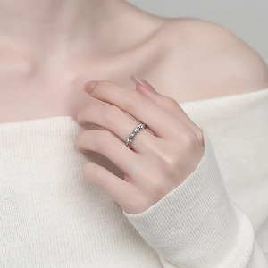 Adjustable silver anxiety ring with rotating beads on a single coil worn by a model