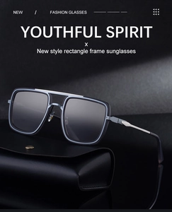 Detail of square sunglasses with double metal bridge on a black leather case