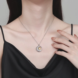 Elegant silver crescent moon and gold heart necklace on female model collarbone
