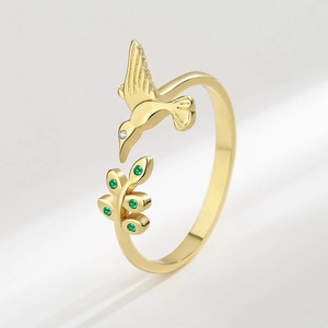 Bague dorée ajustable ornée d'un colibri coloré et d'un motif de feuilles vertes