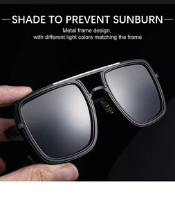 Close-up of black square sunglasses with metallic double bridge and gray lenses