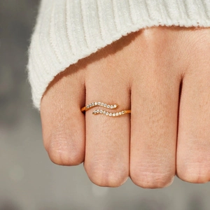 Minimalist gold wave ring with zircon pave crystals on fingers for elegant style