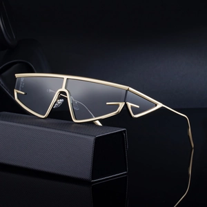 Futuristic cat-eye sunglasses with gold metal frame and dark lenses on a black case
