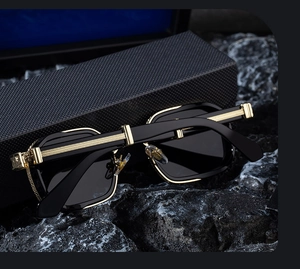 Detail of luxury square sunglasses with golden C-decor hinge and textured case