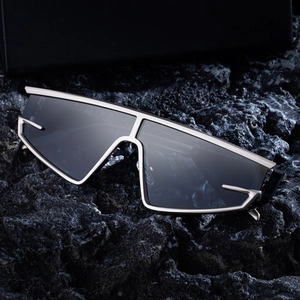 Futuristic silver metal cat-eye shield sunglasses for men with dark lenses on black rock