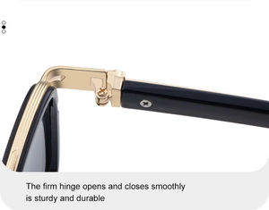 Close-up of durable golden metal hinge with reinforced screws on black sunglasses